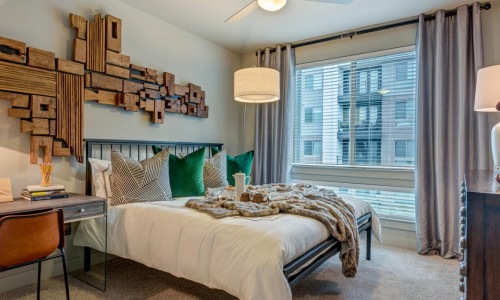 a bedroom with a bed desk and a chair
