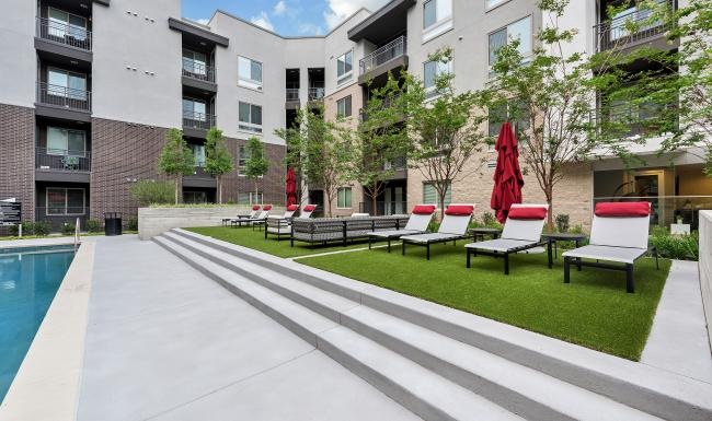 a pool and chairs by a building