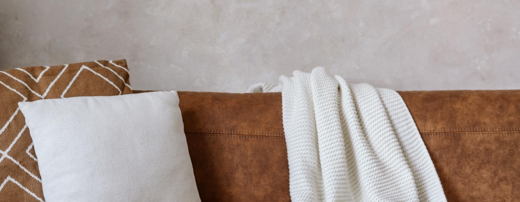 a couch with pillow and a blanket