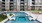 a pool with lounge chairs around it